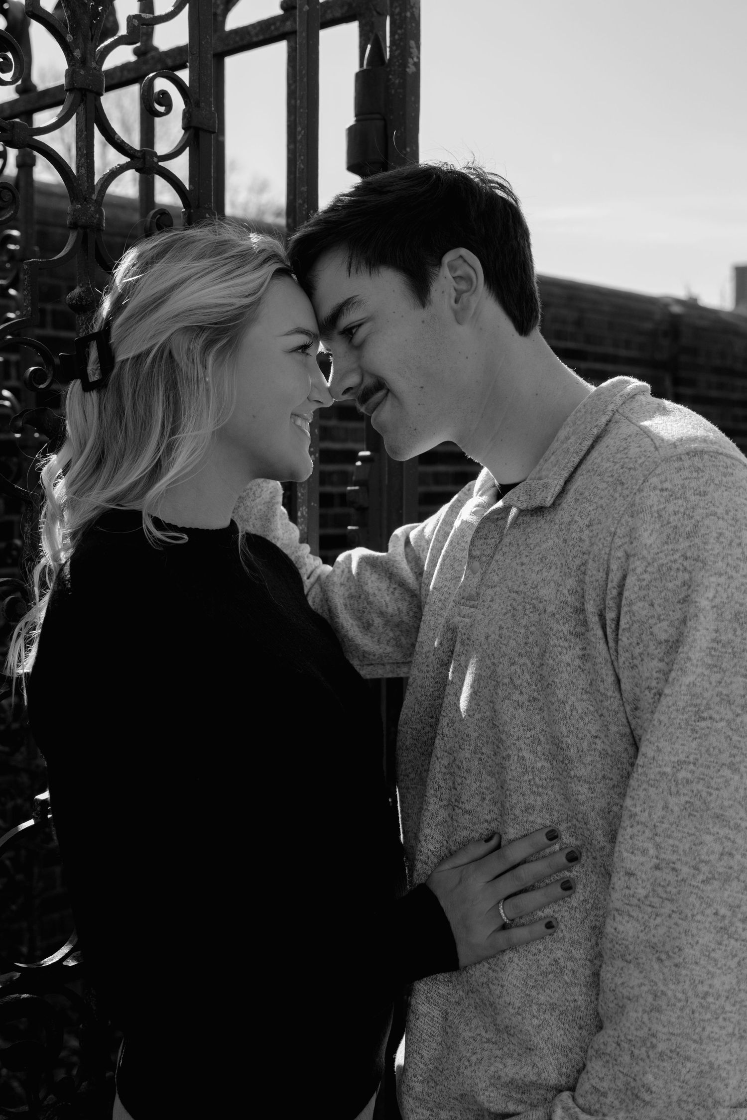 A romantic black and white photo series showing a couple sharing tender moments and kisses against an urban backdrop.