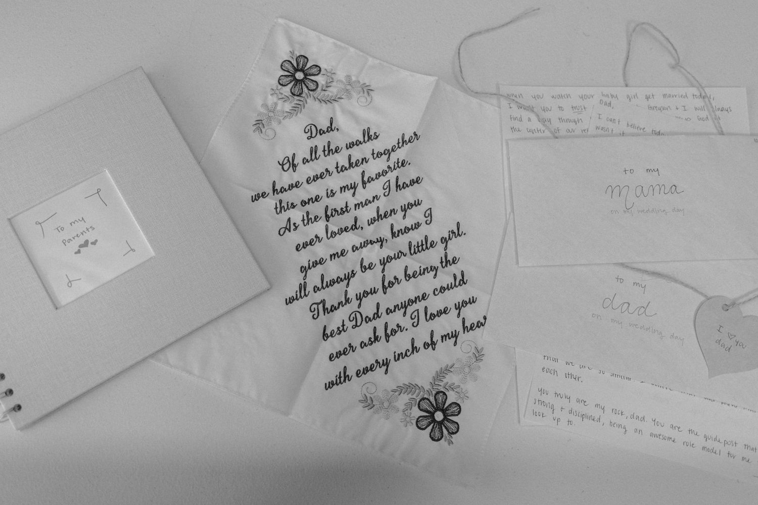Black and white photo of handwritten wedding letters and cards arranged on a white surface.