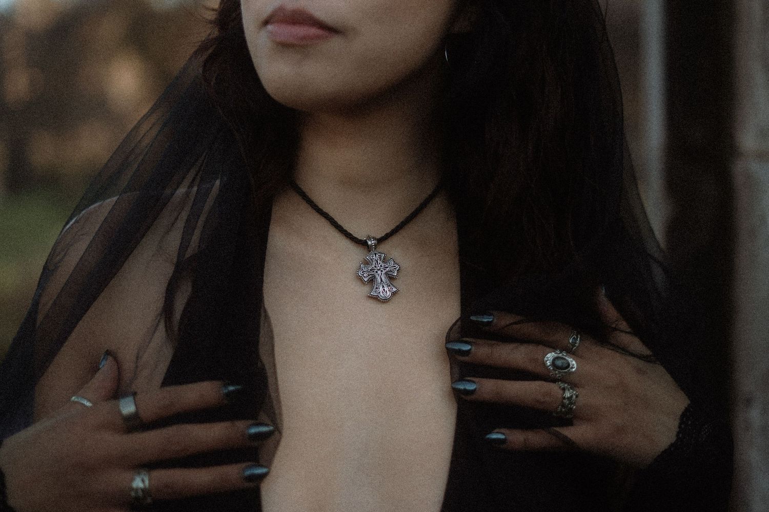 A person with long dark hair wearing a necklace poses in a series of similar closeup shots.