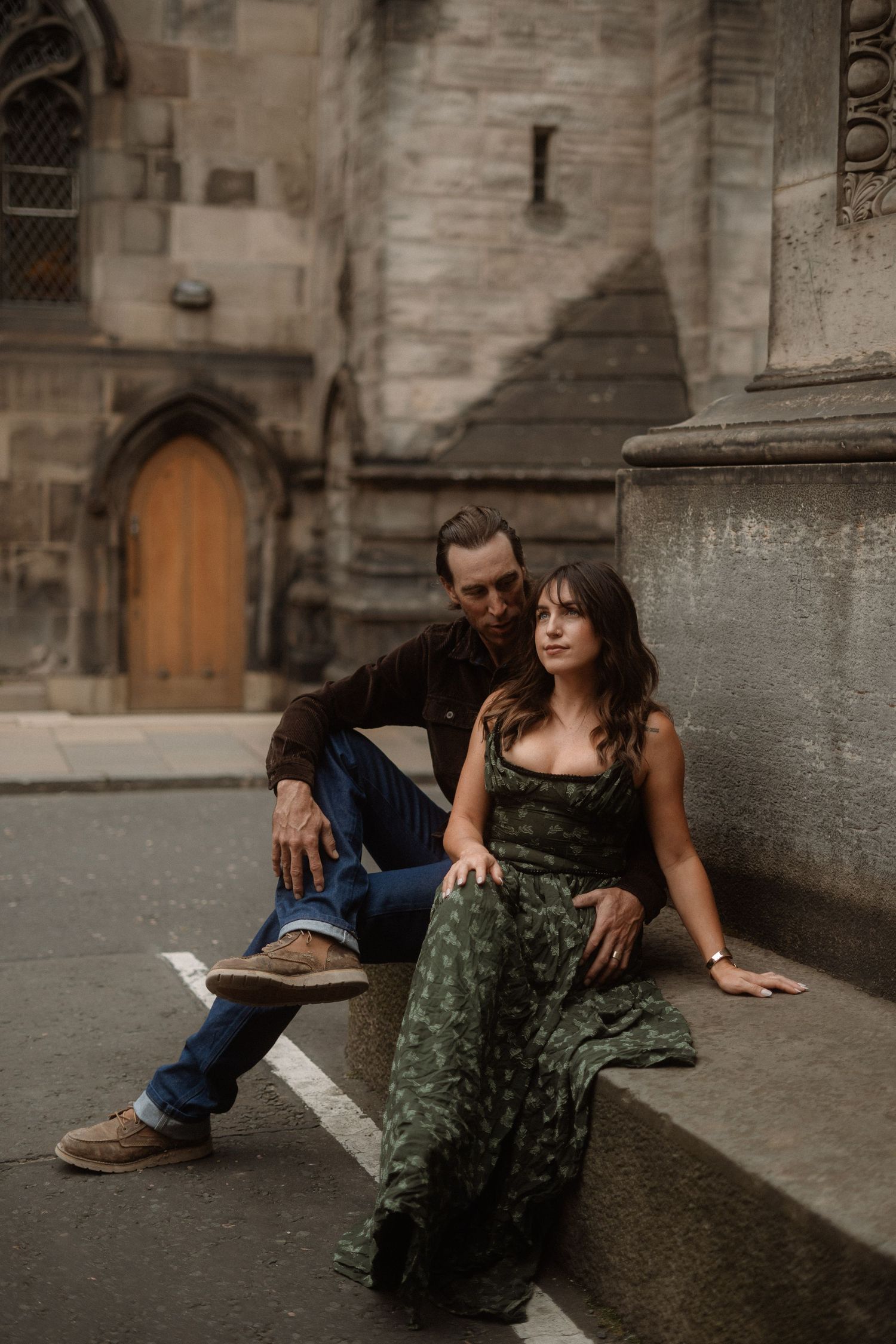 Artistic portrait session against weathered stone walls of a historic building.