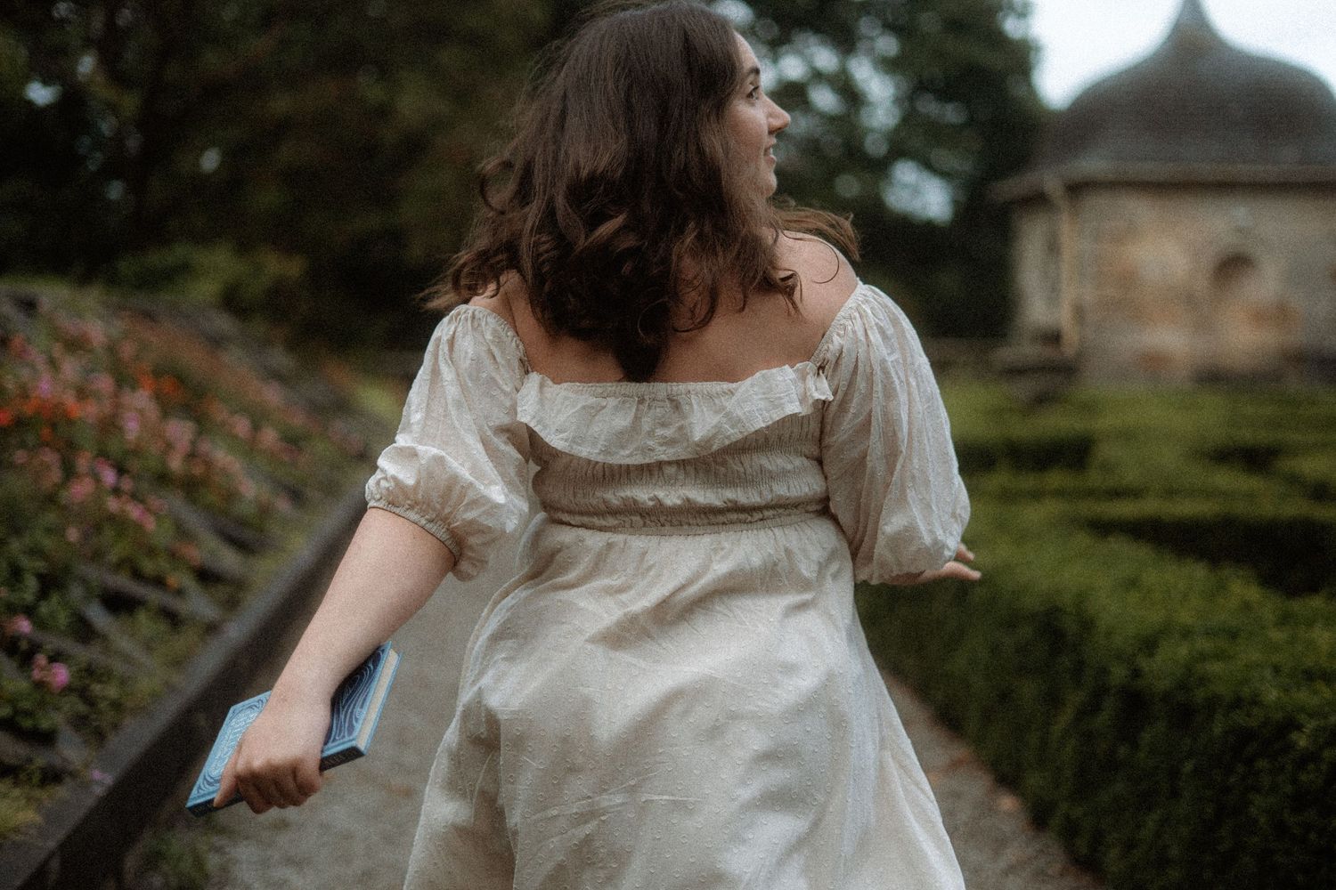 Women dressed in white dress runs through an Italian garden. cottagecore vibes. Pollok Park, Scotland.