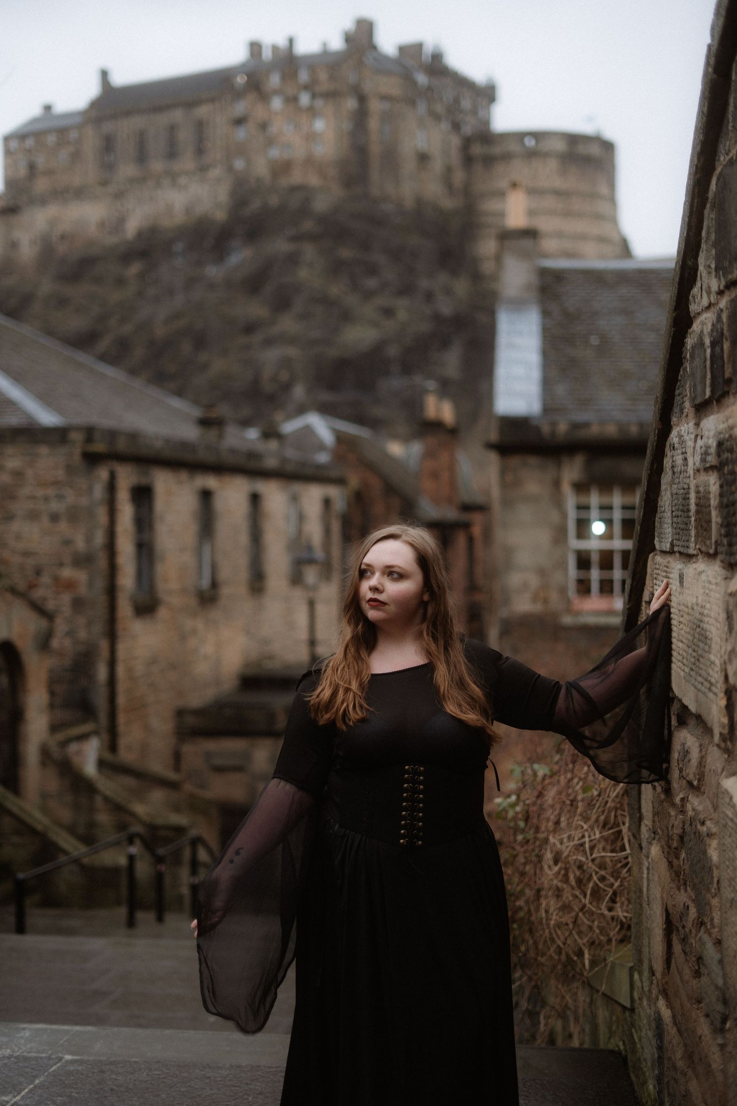 A series of photos showing a person in black clothing standing against stone walls with Edinburgh Castle in the background.