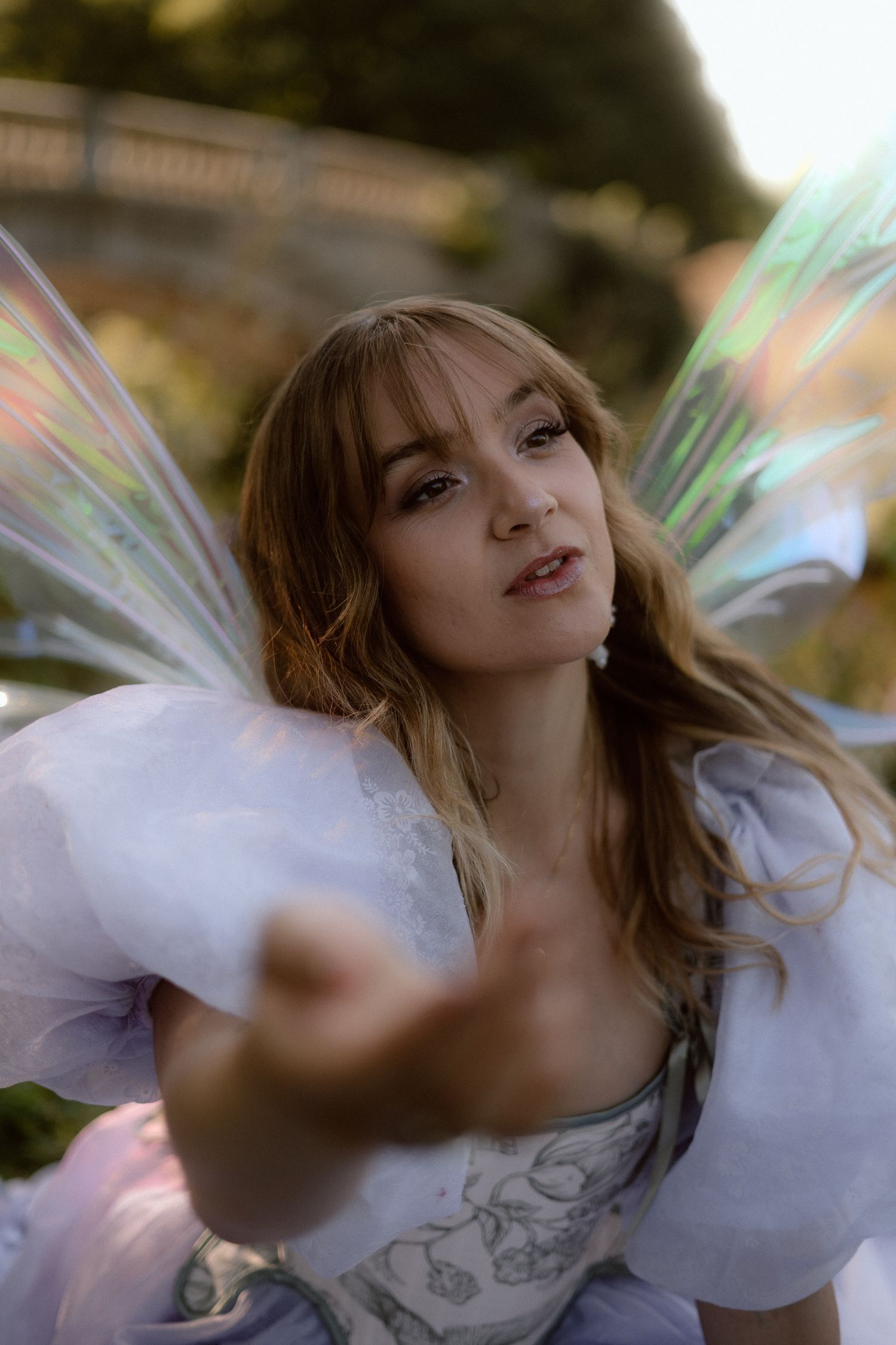 A person in white clothing spins gracefully outdoors creating a dreamy ethereal effect with motion blur.