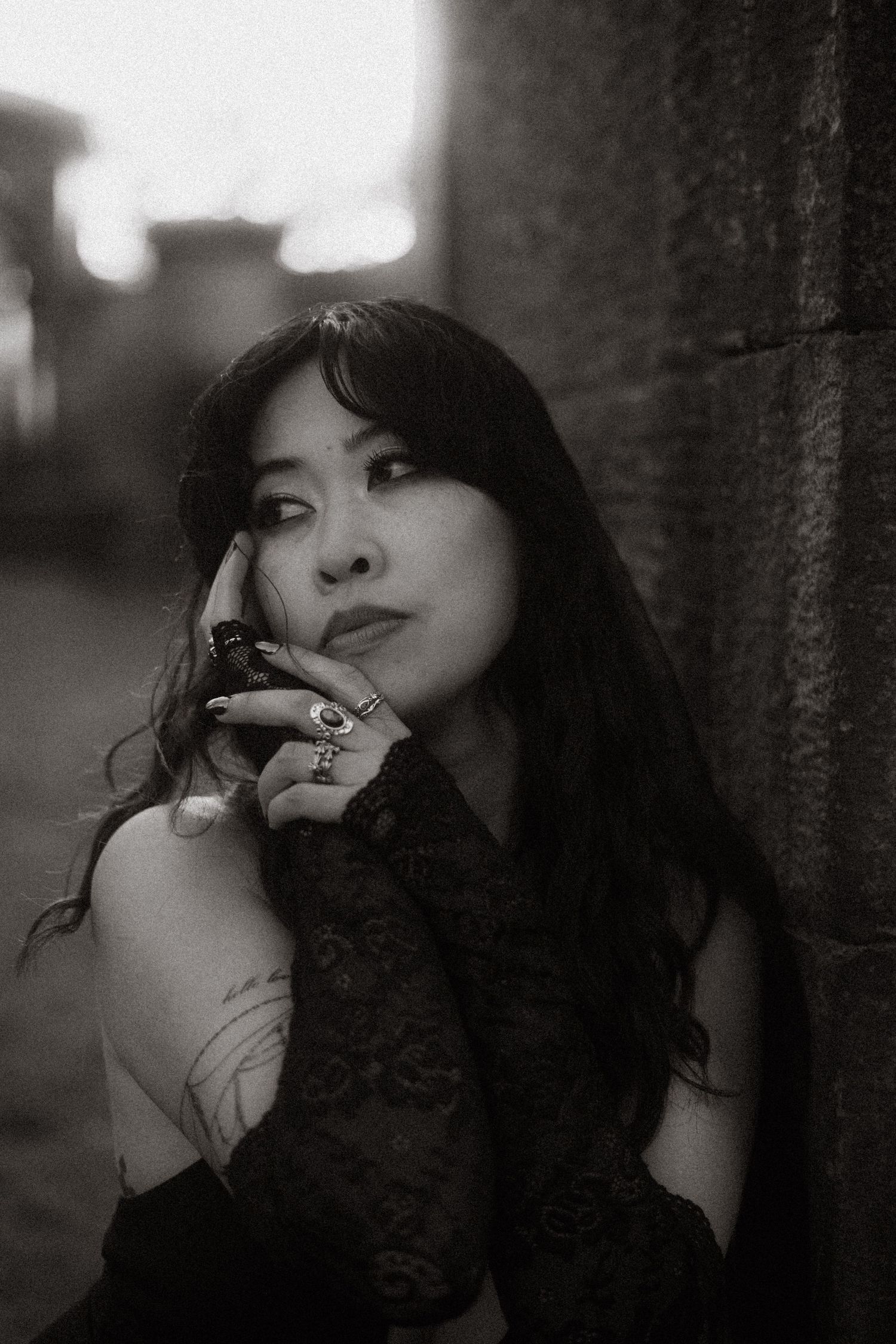 A black and white artistic portrait series showing dramatic lighting and moody expressions against a dark background.