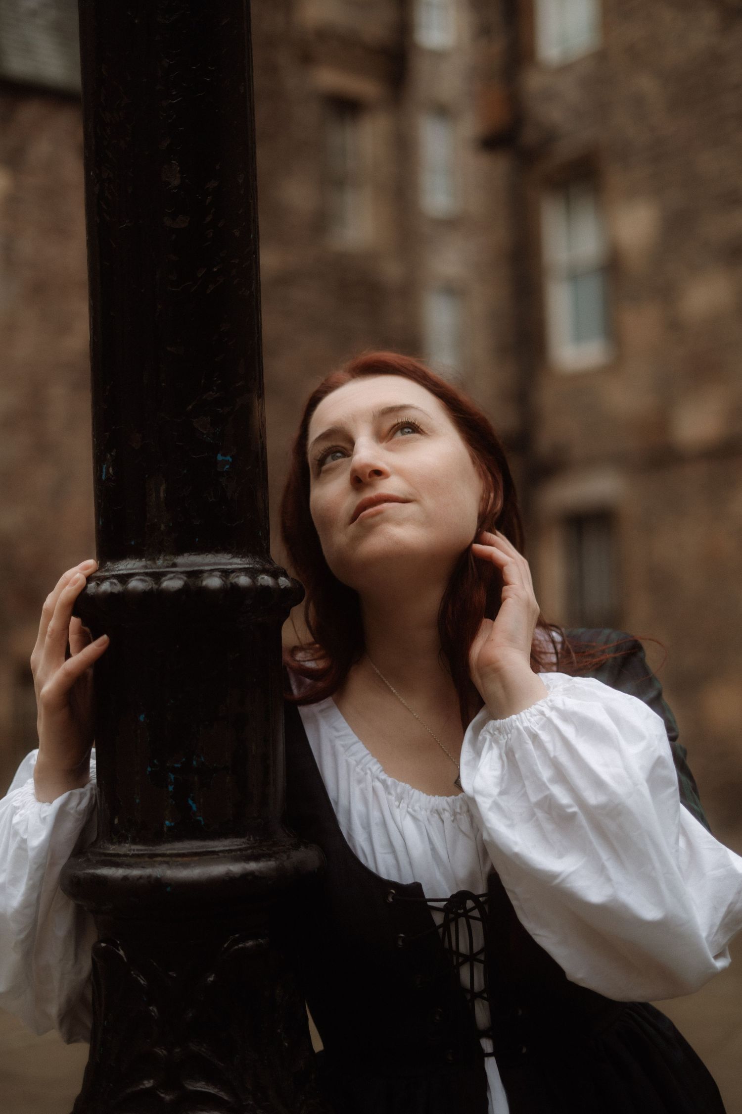 A sequence of photos showing someone in a white blouse looking upward while leaning against dark columns.