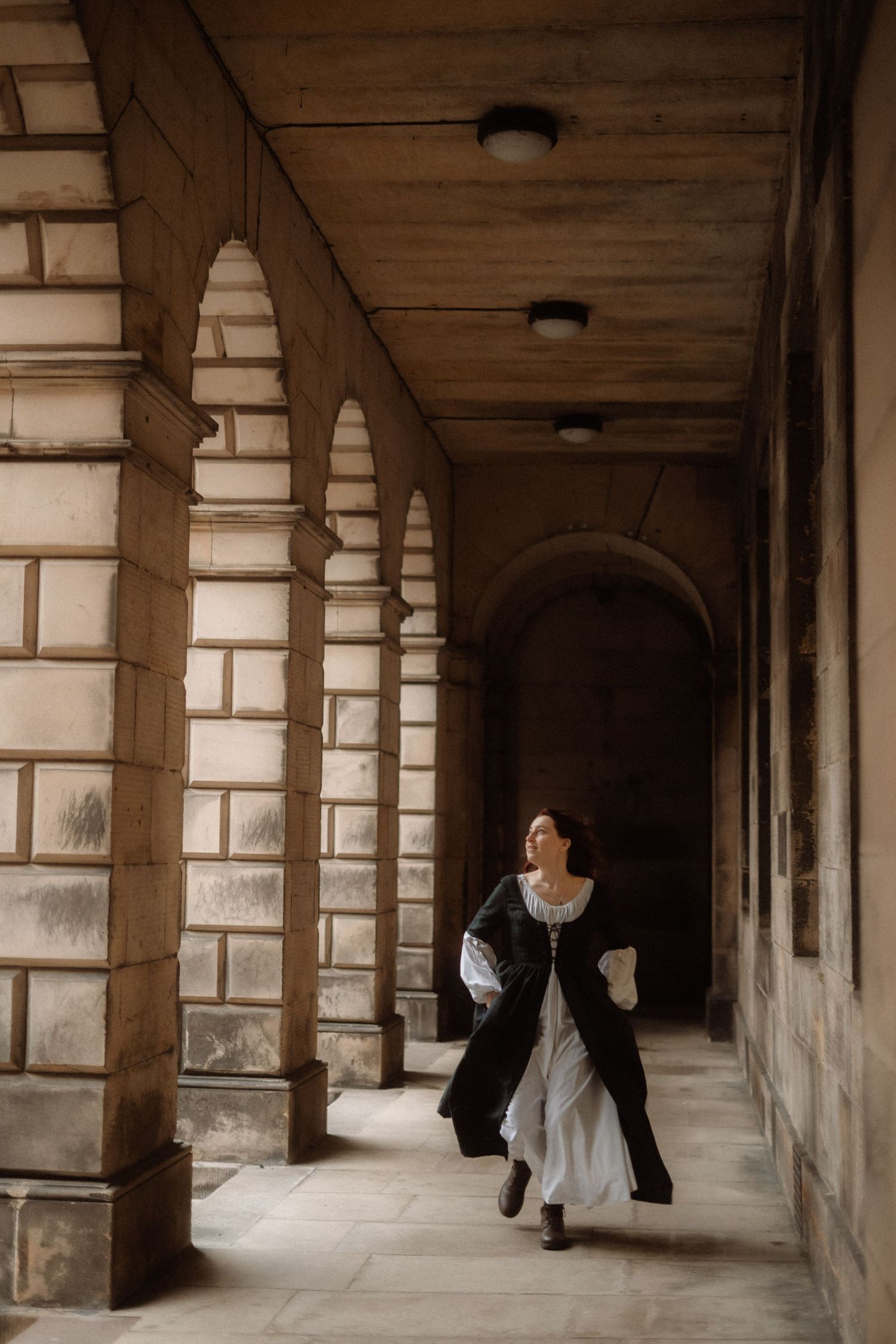 A series of four connected photos showing a stone colonnade hallway with arches and dramatic lighting.