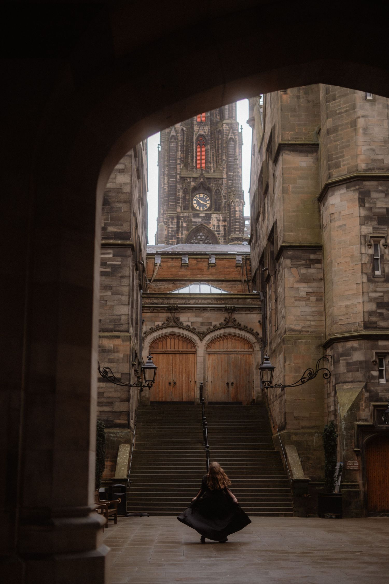A sequence of stone archways and staircases inside a historic medieval church or cathedral with dim lighting.