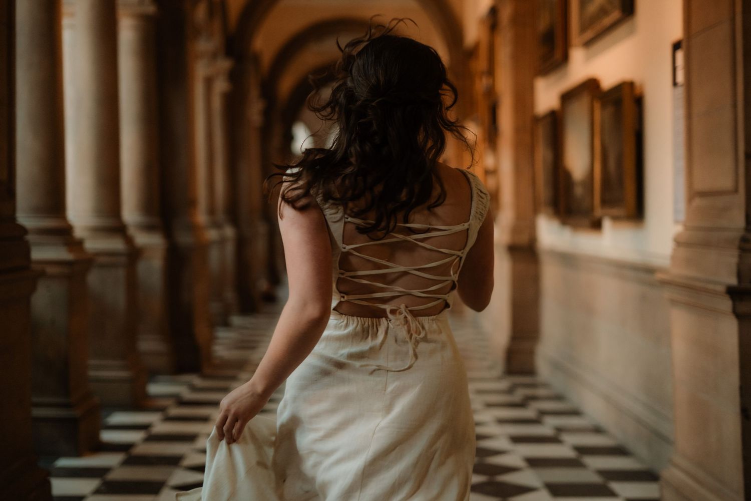 Woman in white dress running through art gallery, Scotland