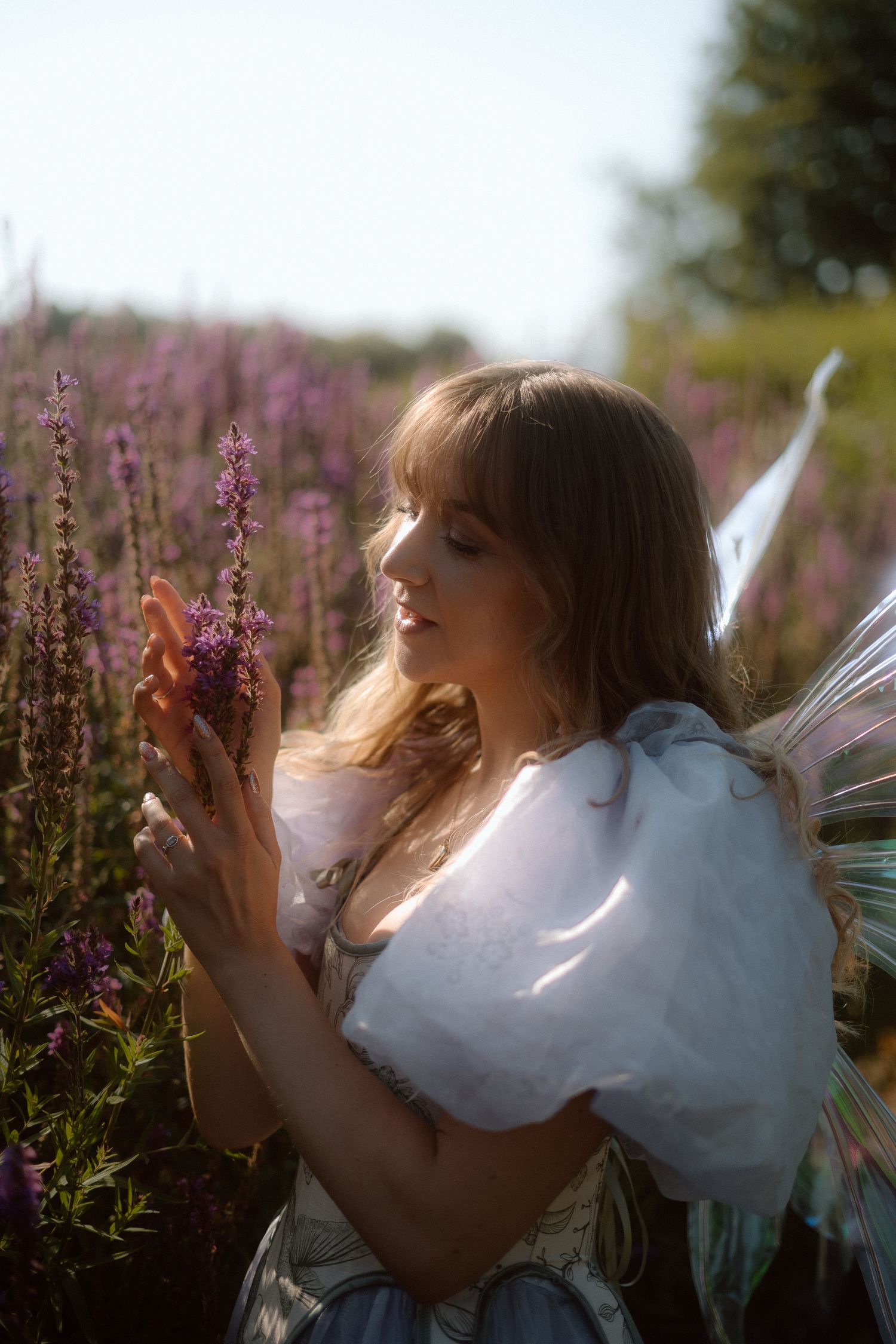 A flower fairy holds up a flower in the garden in Edinburgh, Scotland.