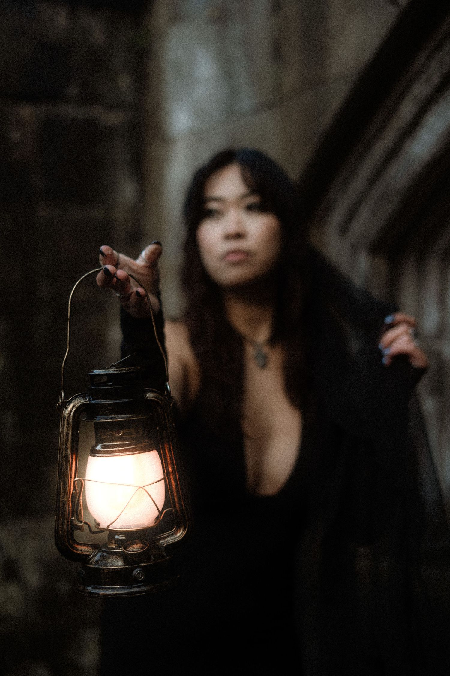 A vintage oil lantern glows warmly in a dark atmospheric setting with soft bokeh lighting effects.