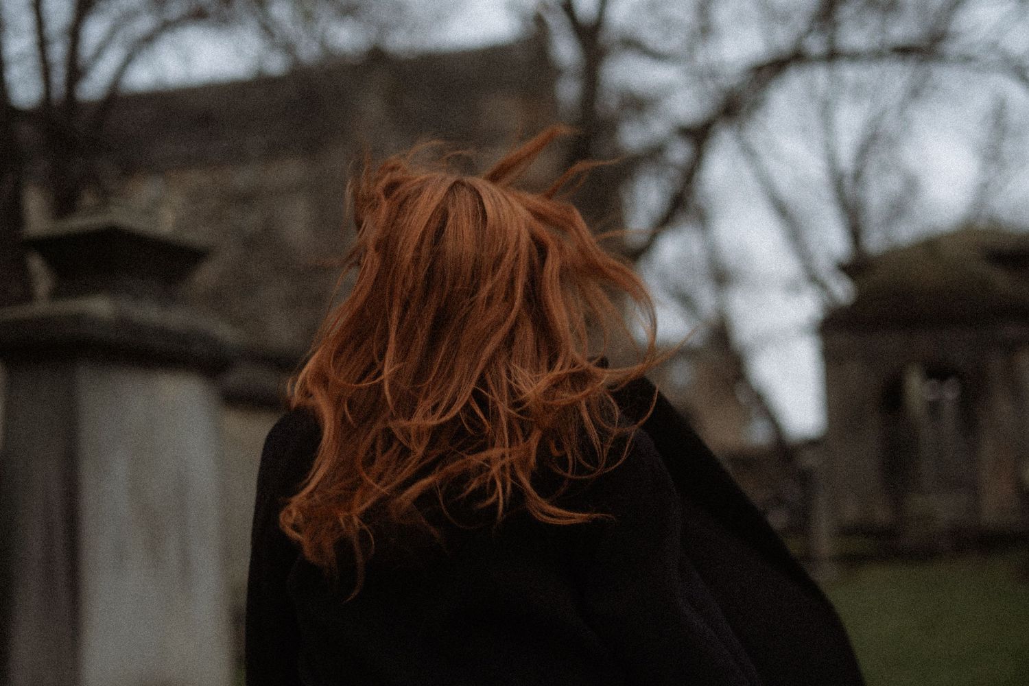 Woman with red hair running through graveyard, Scotland, moody and witchy vibes