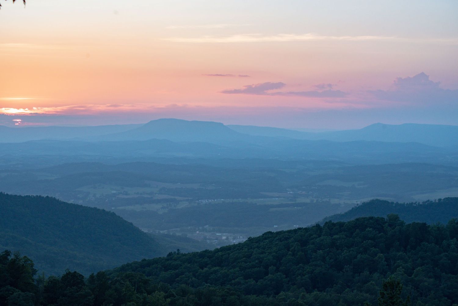 Blue Ridge Parkway mountain landscape at dusk with layered Appalachian ridges and evening light.