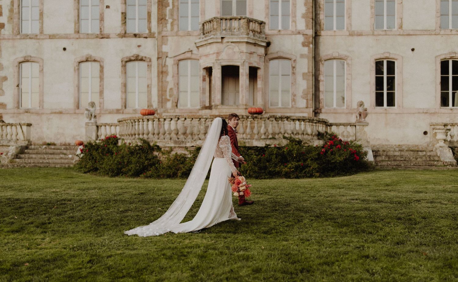 Les mariés marchent devant le magnifique château du Vignau