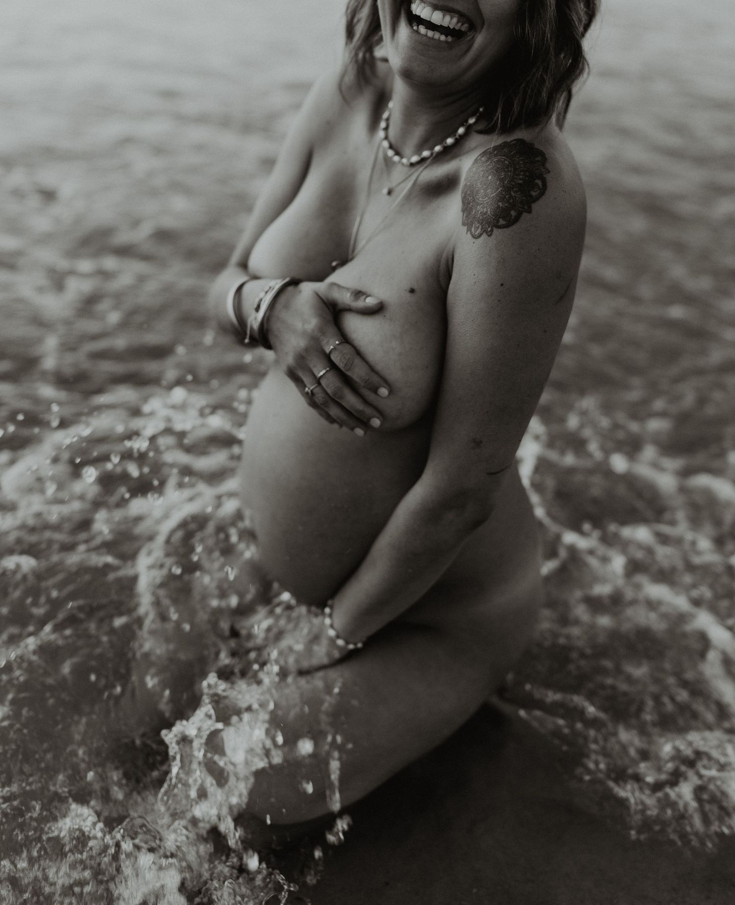 Black and white photo sequence showing a person joyfully playing and splashing in ocean waves at the beach.