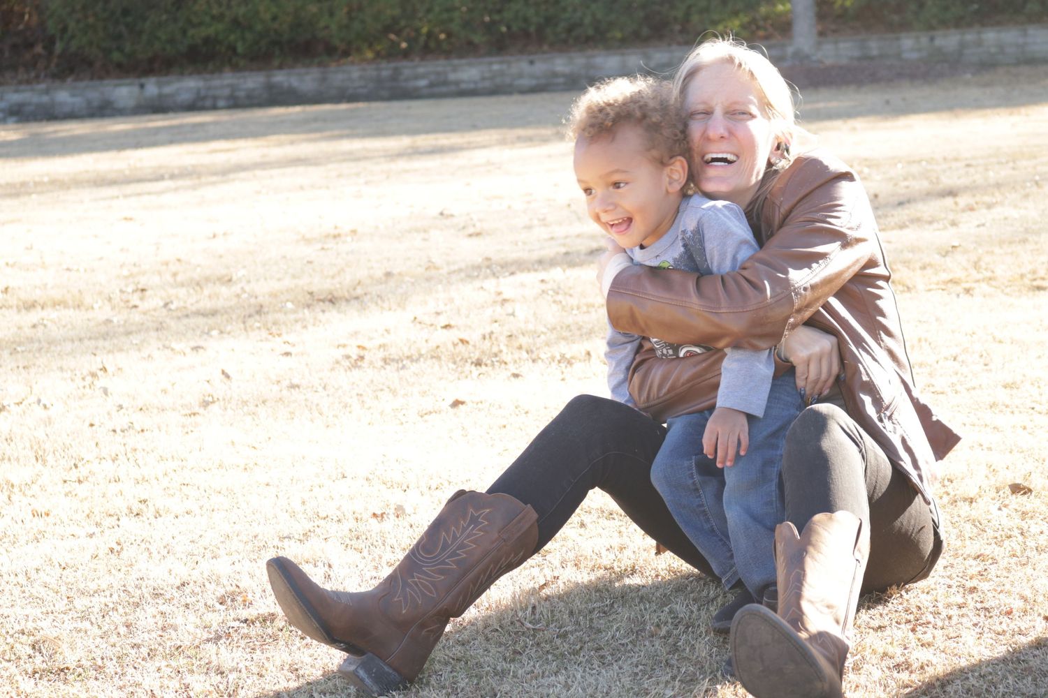 This is a photo of a very youthful grandmother hugging one of her grand kids.