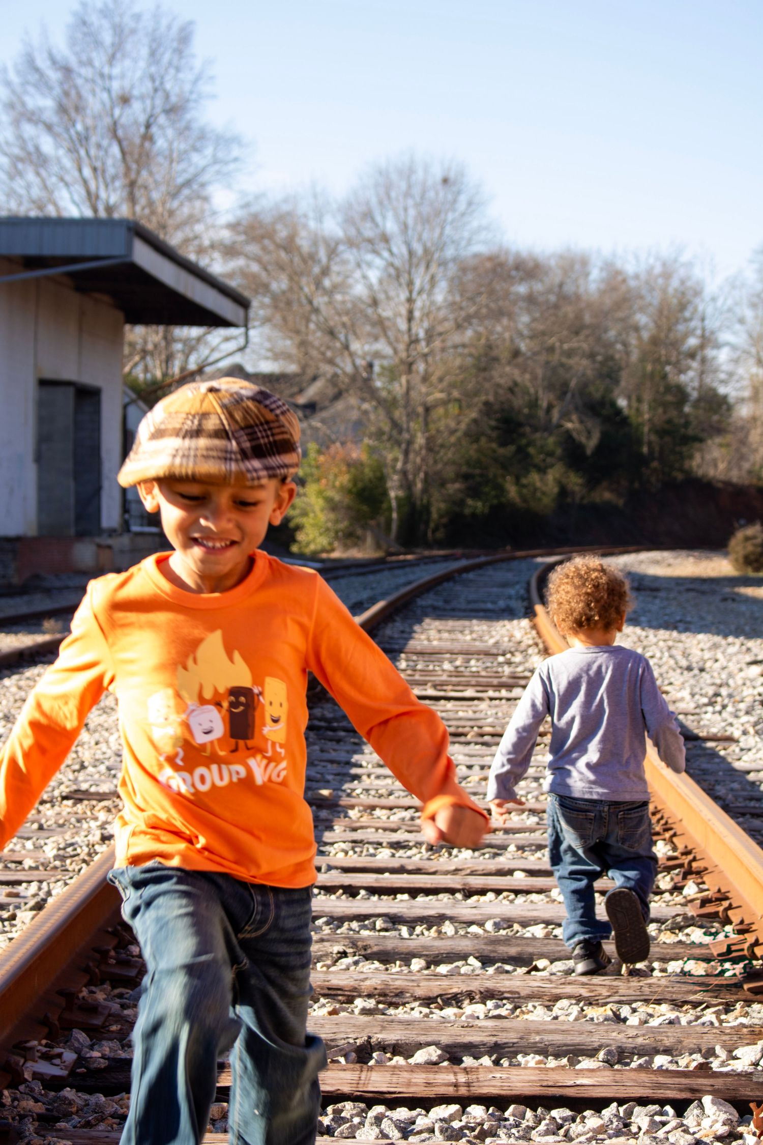 This is a cute photo of the kids playing on the unused train tracks.