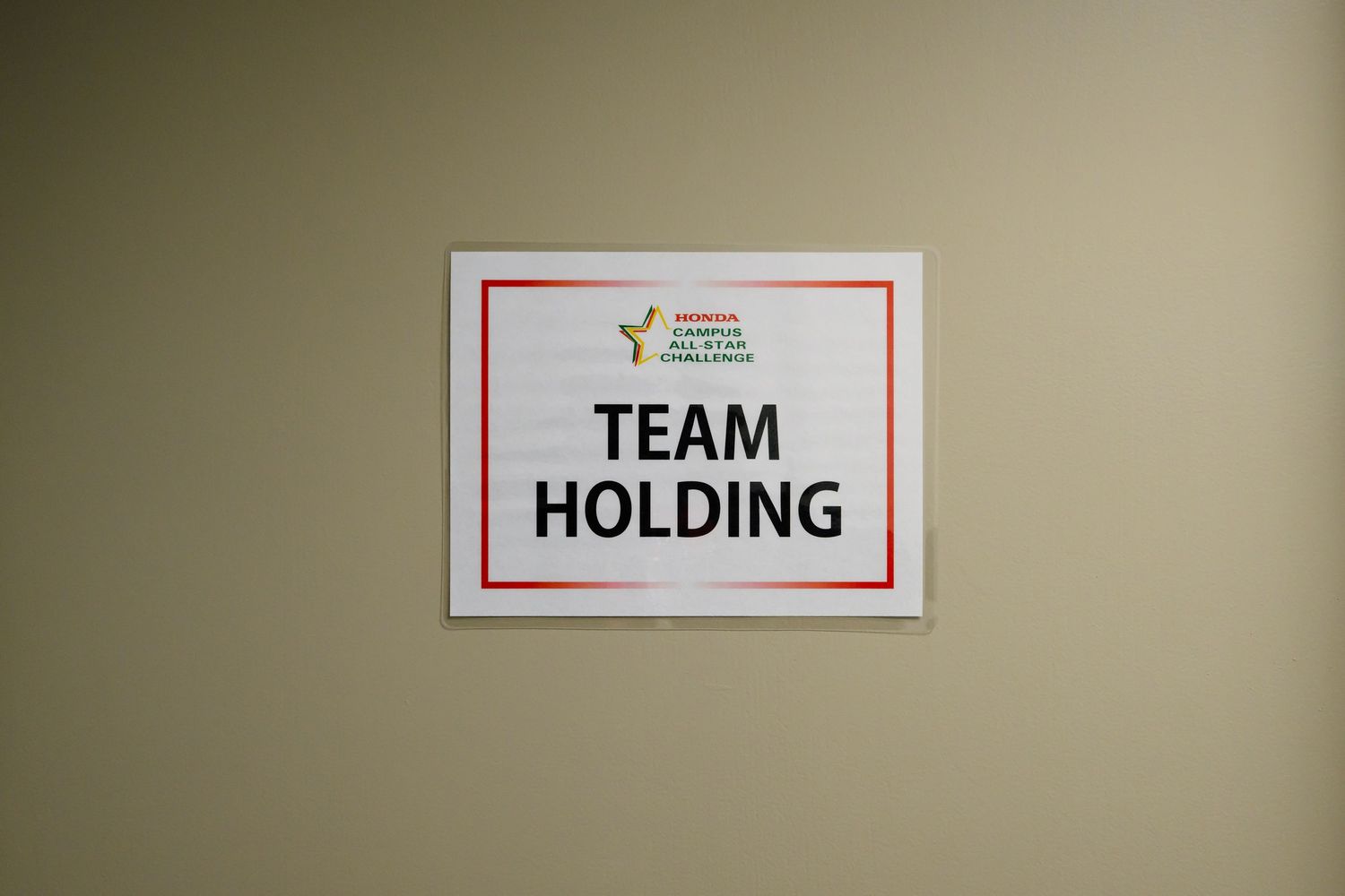 Team holding area signs and directional markers for event organization.