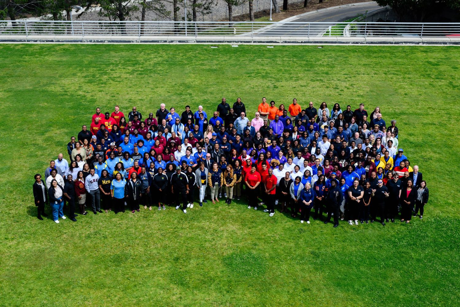 Large groups of people gathered on a green lawn shown in panoramic sequence.