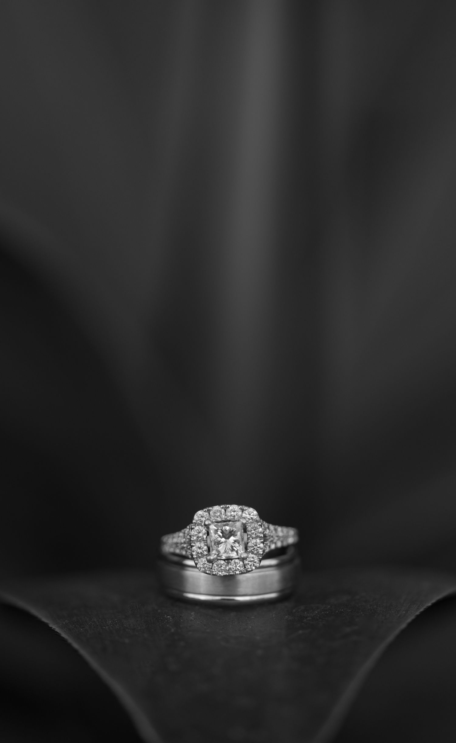 Diamond engagement ring detail shots on dark background.