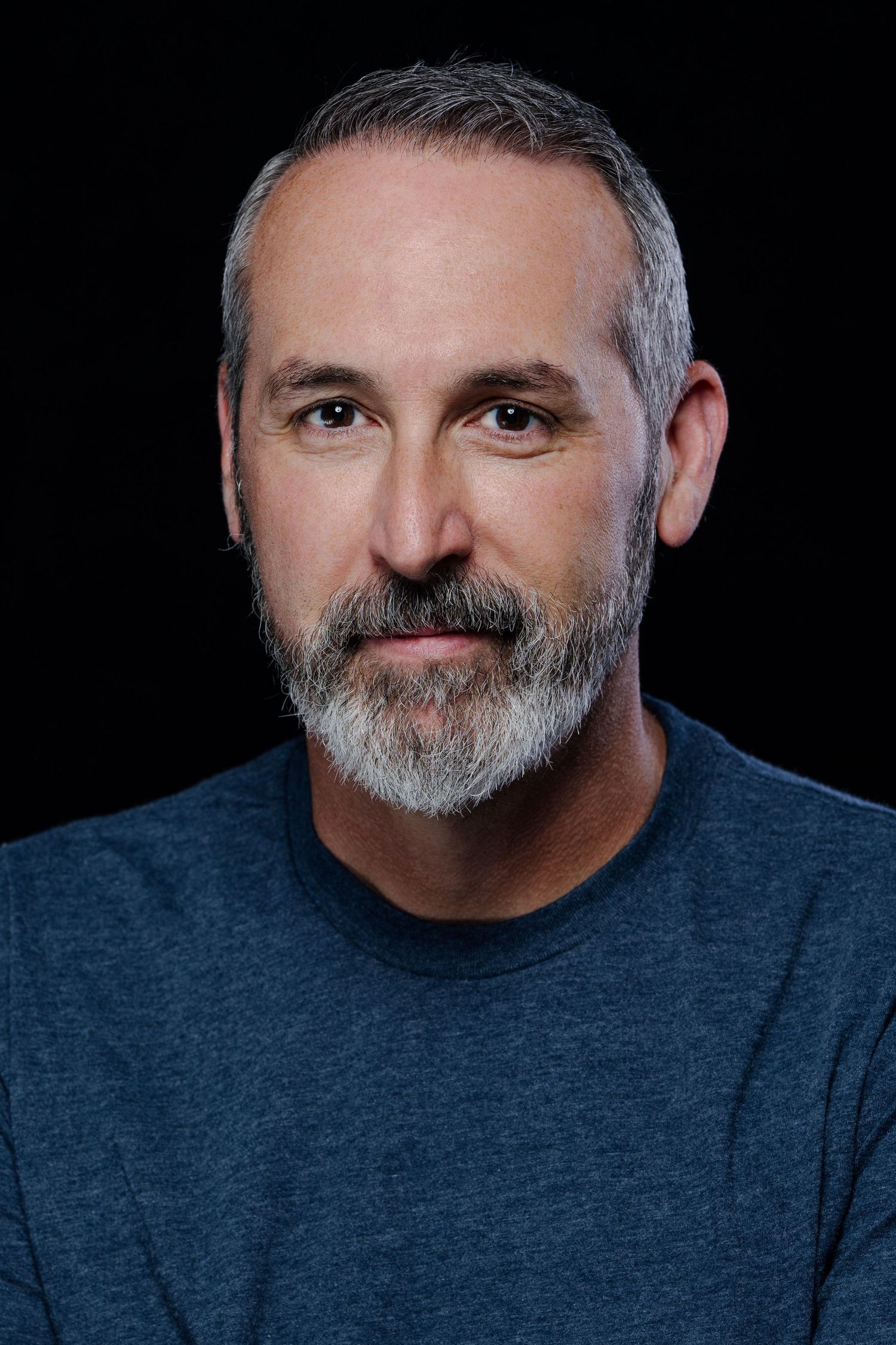 Series of dramatic headshots showing a person with grey beard wearing dark clothing.