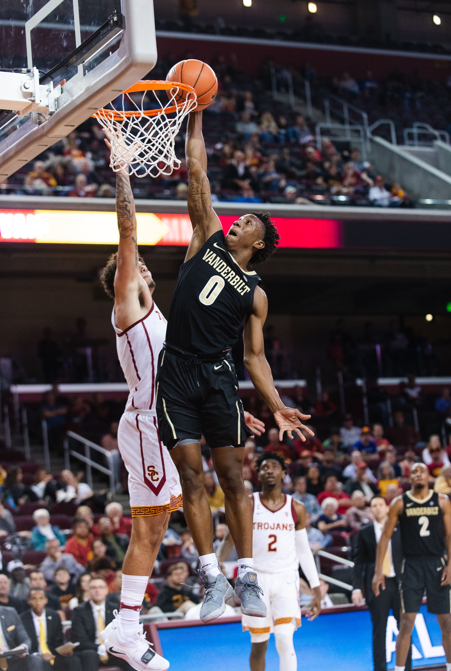 Basketball player attempts to block shot during competitive game.