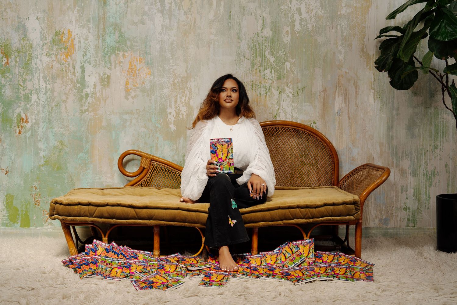 Vintage chaise lounge setup against weathered wall with artistic portrait series.