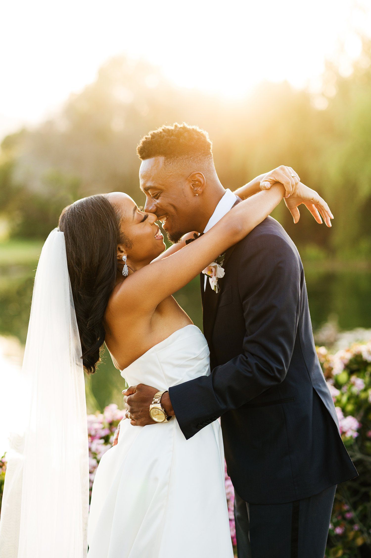 Sunset wedding portrait with couple sharing romantic moment against golden light.