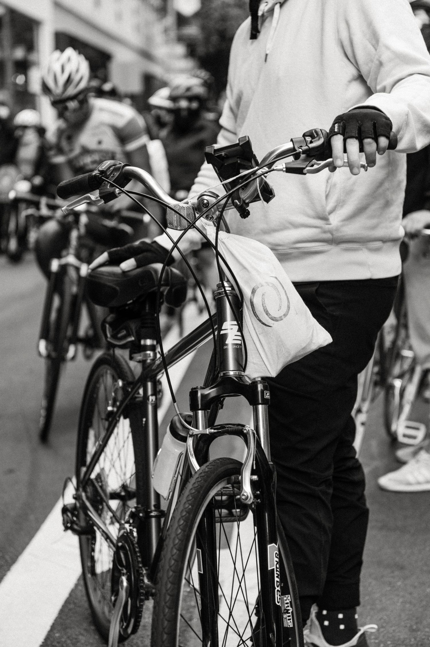 Close-up black and white photo of someone holding bicycle handlebars.