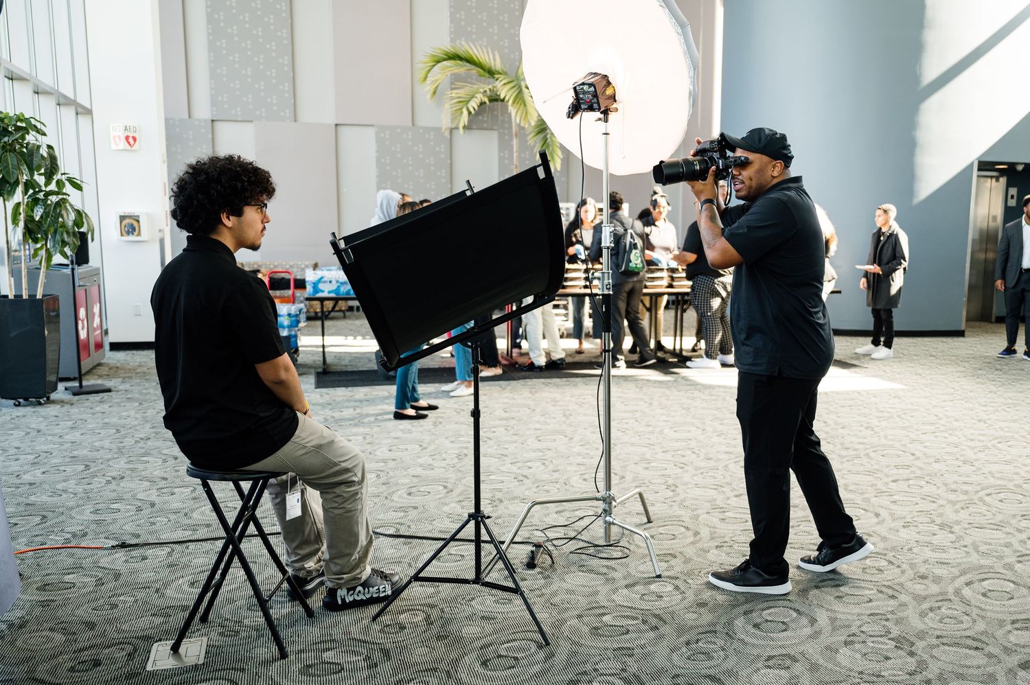 Behind-the-scenes photo shoot setup with camera equipment and lighting in an elegant venue.