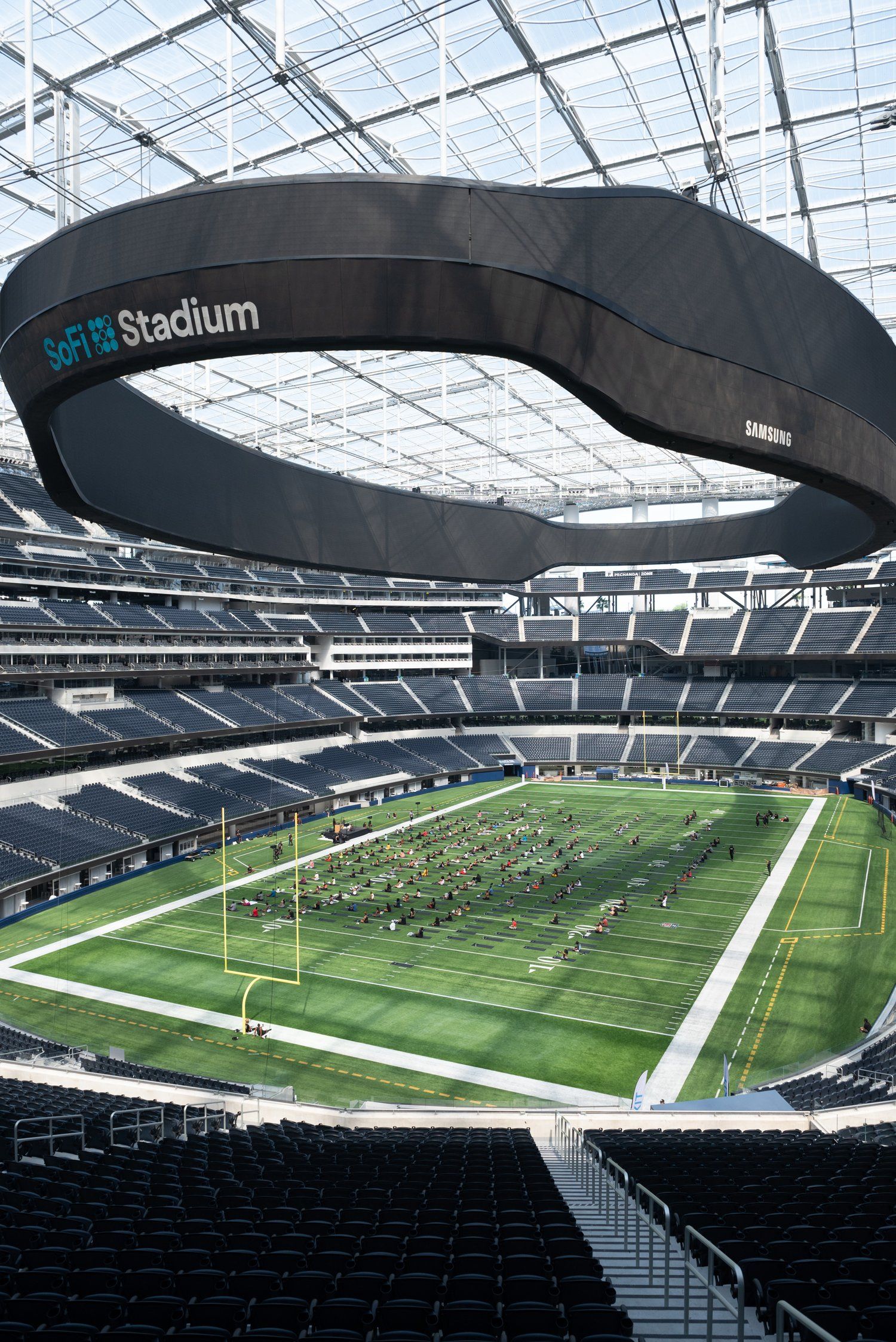 Panoramic view of an indoor football stadium with retractable roof and green playing field.