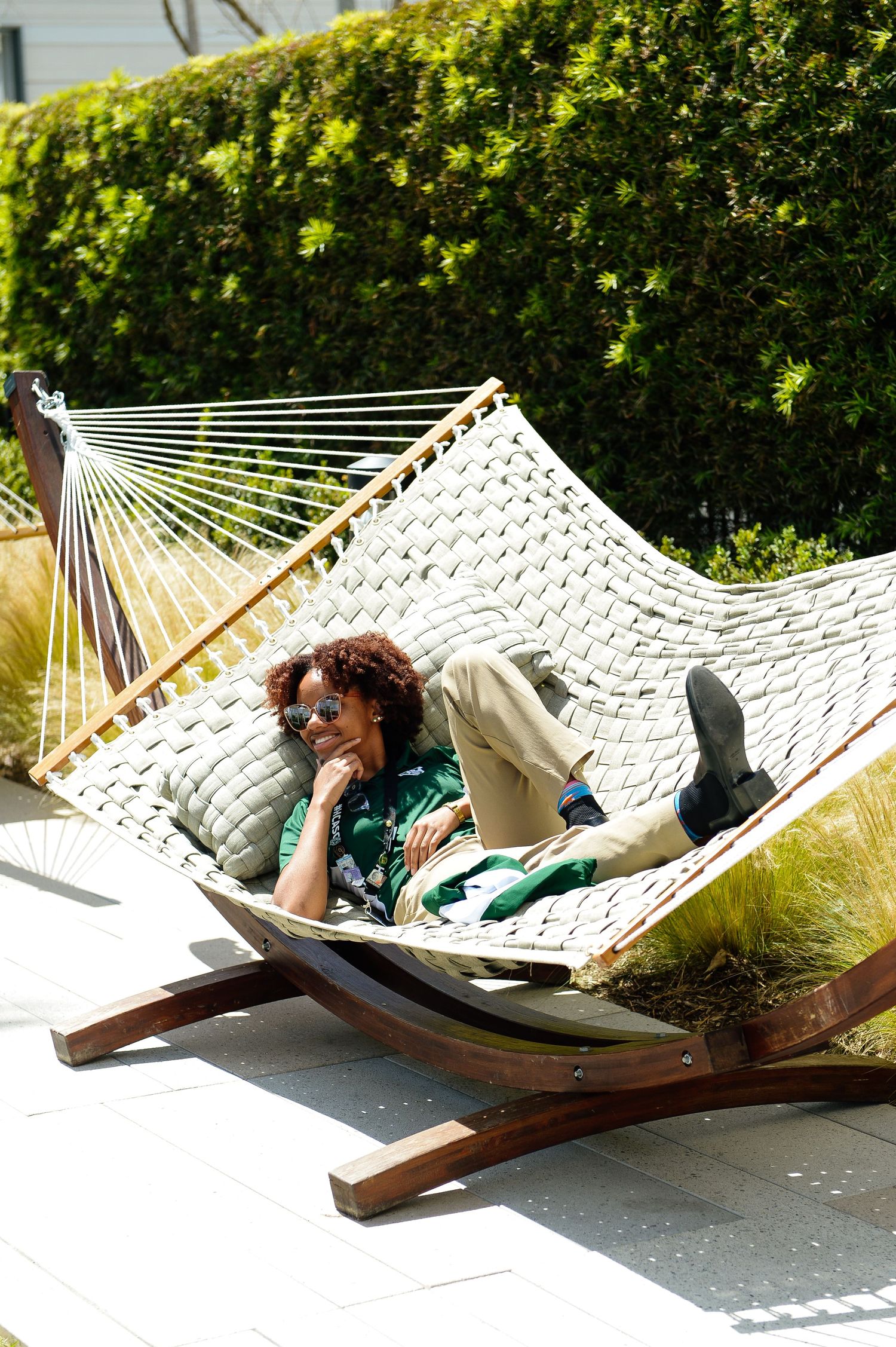 Series of photos showing someone relaxing in a white rope hammock on a sunny patio.