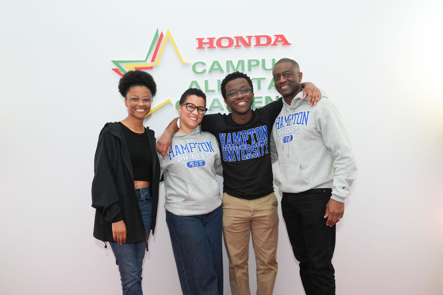 Four students smile together at Honda Campus All-Star Challenge event, wearing Hampton University sweatshirts.