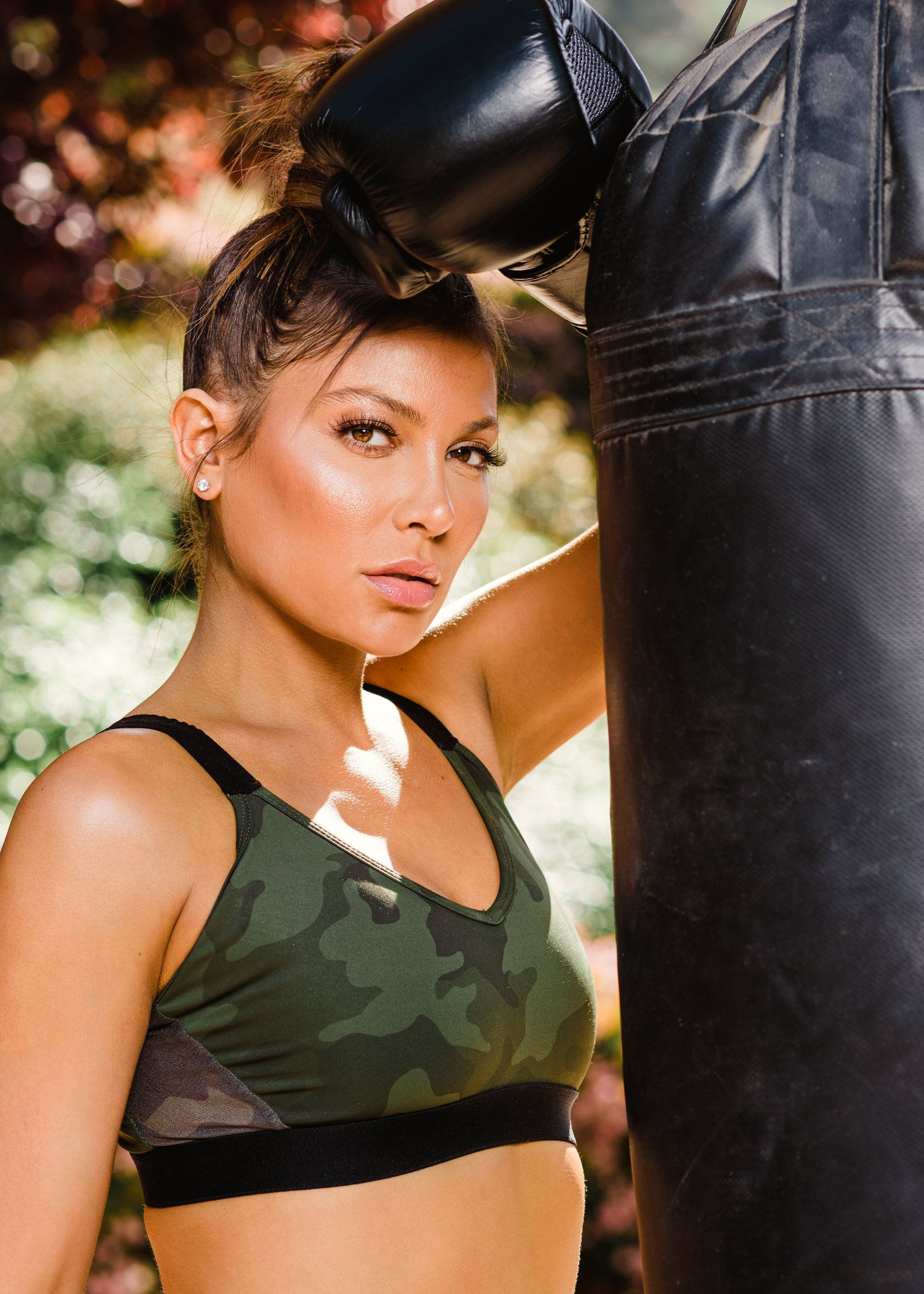 Fitness photoshoot with camouflage sportswear near boxing equipment.