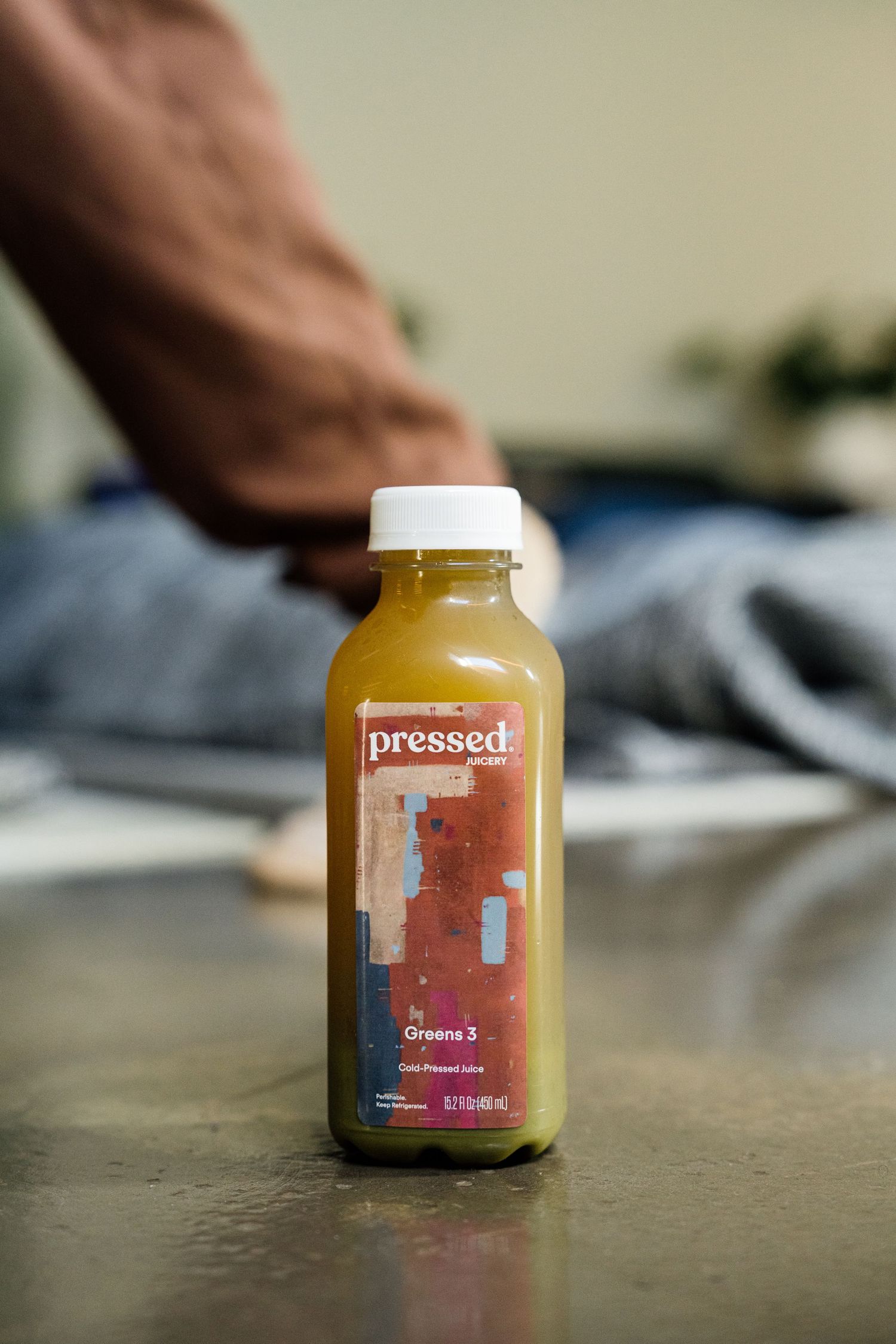 A glass bottle of pressed juice shown in a sequence of close-up product photography shots.