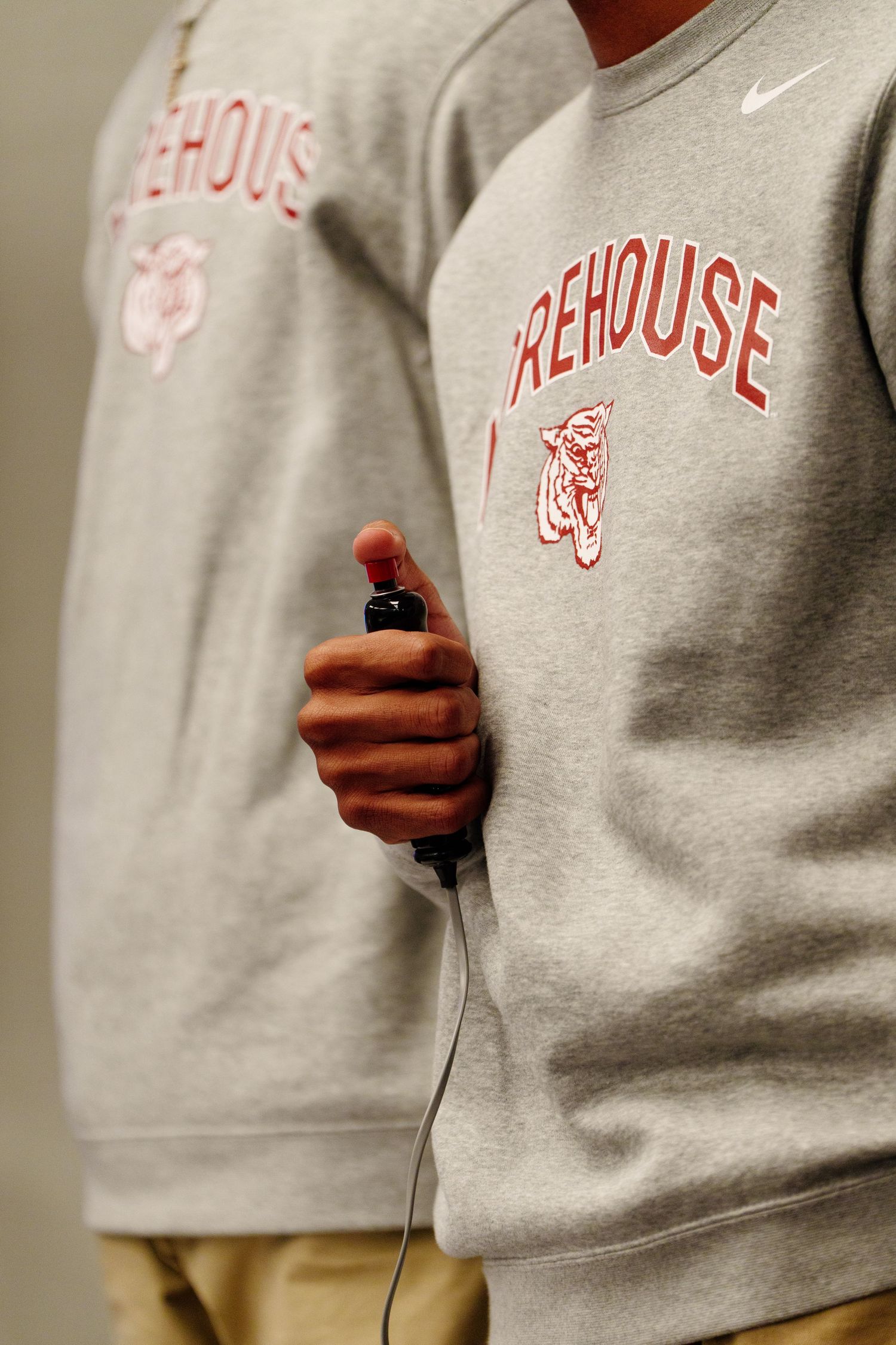 Close-up of grey Nike Firehouse sweatshirt with someone holding a microphone.