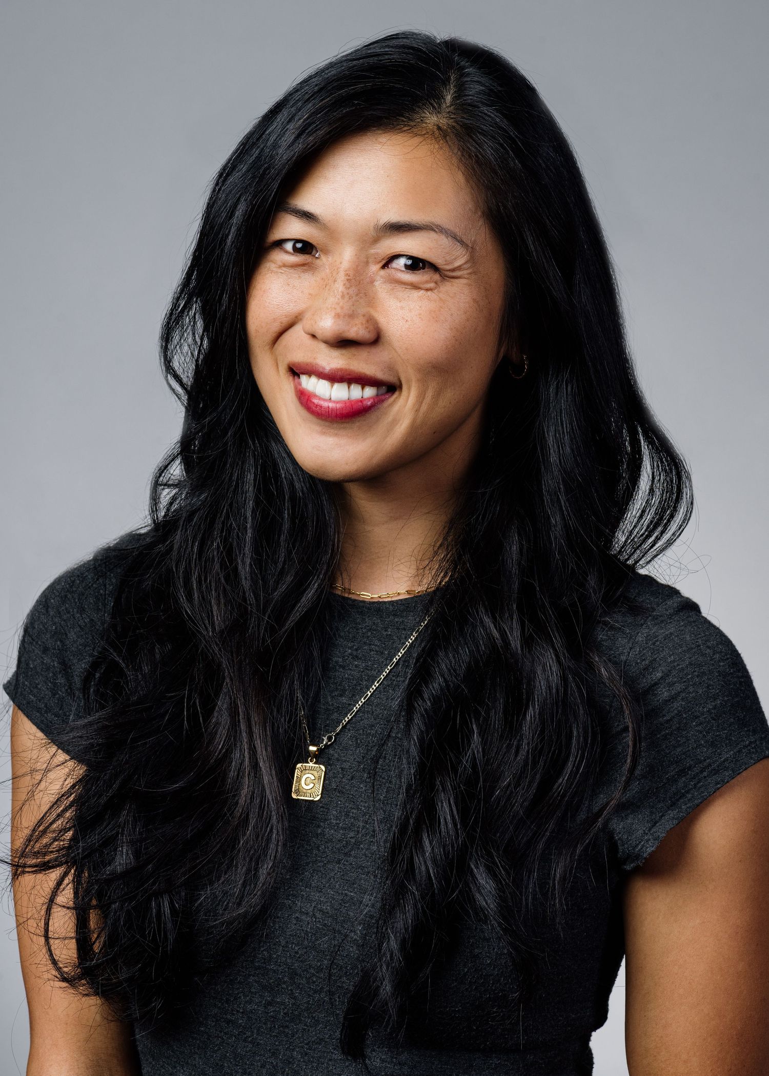 Series of expressive portraits showing joyful poses in black top against grey background.
