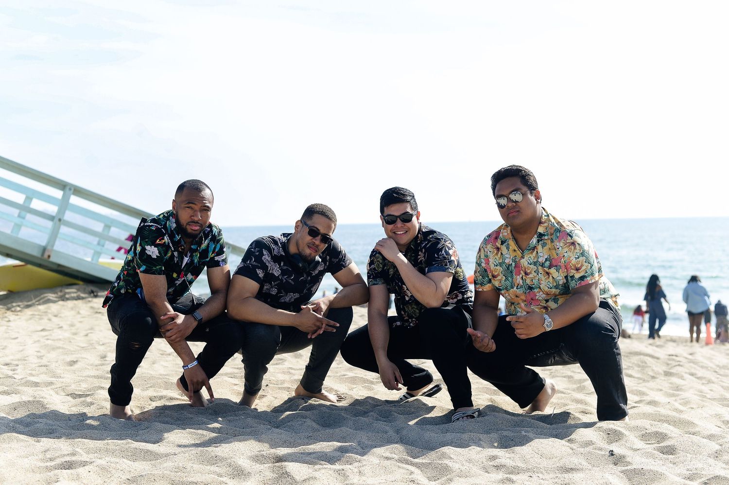 Group of people lying in formation on beach sand during outdoor activity.