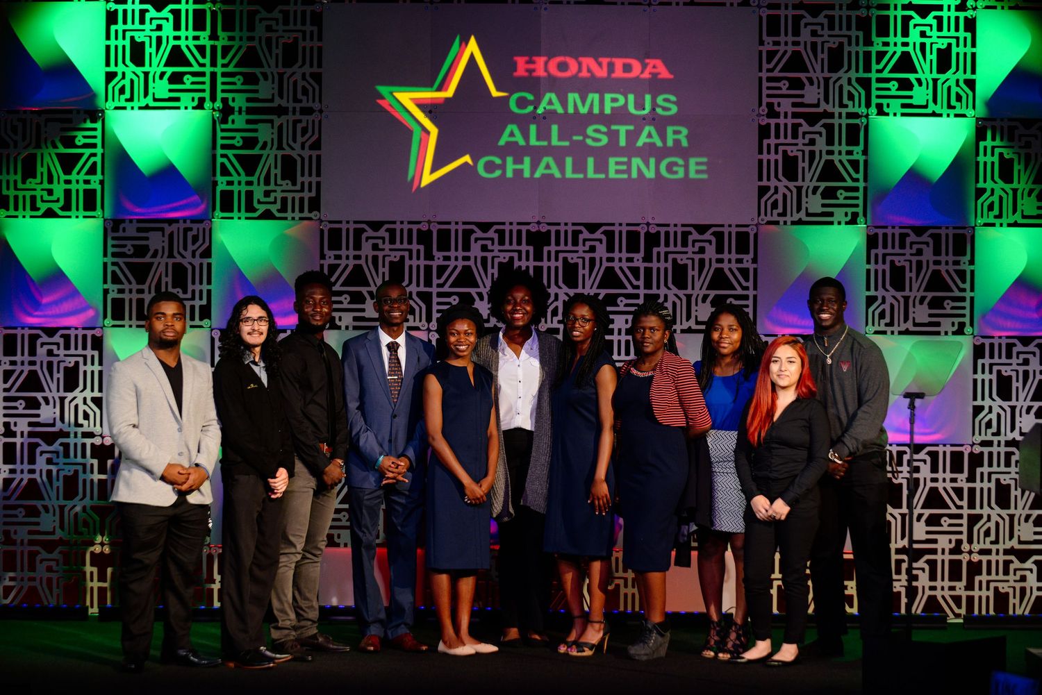 Honda event stage with green lighting and group photo of participants.
