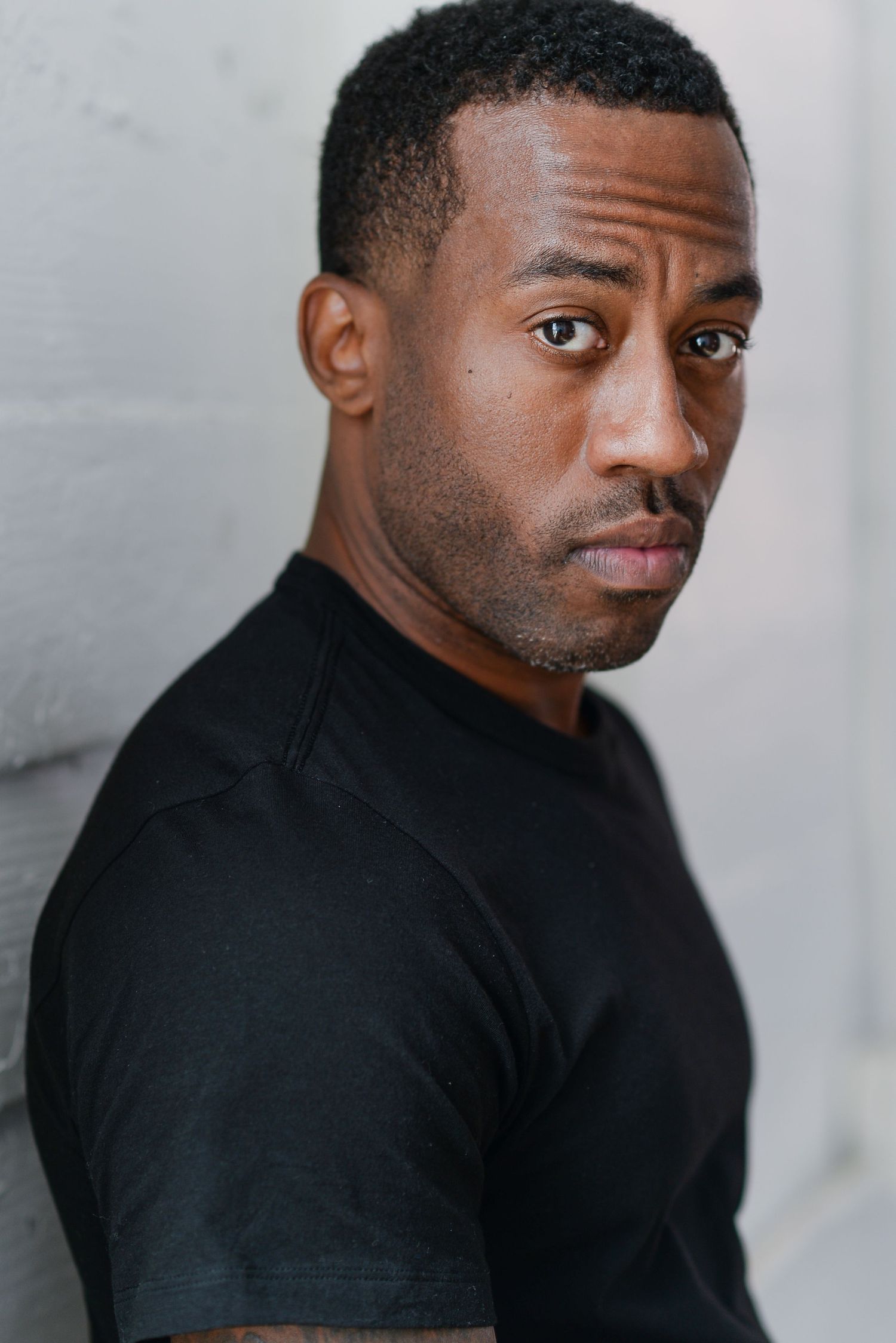 Person in black shirt shown in dramatic side profile portraits against gray background.