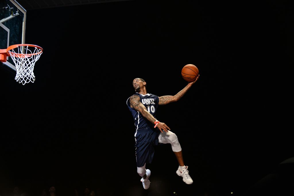 Basketball players performing dynamic dunks and layups during an intense game sequence.