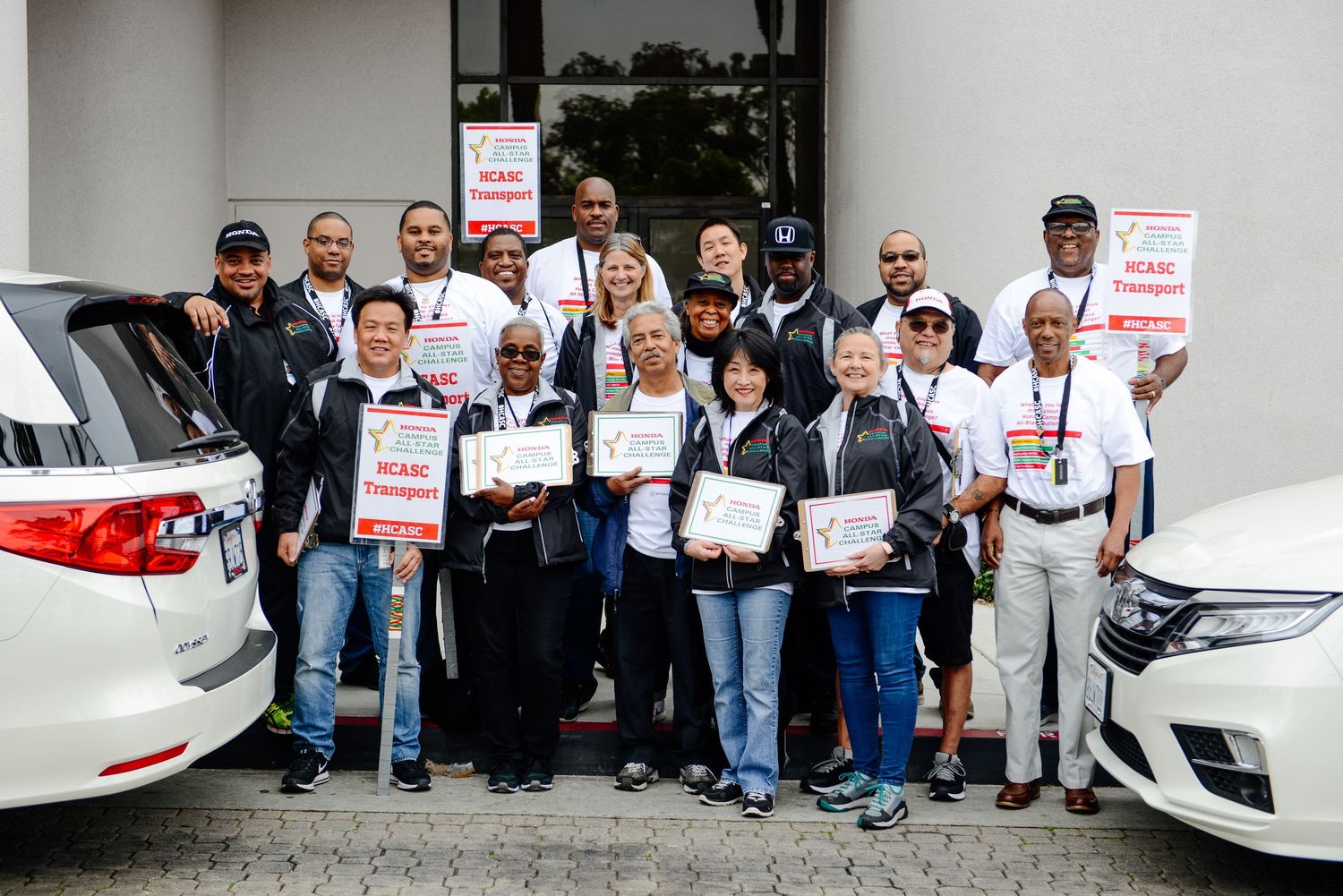 People gathered with signs outside a building during a Honda event.