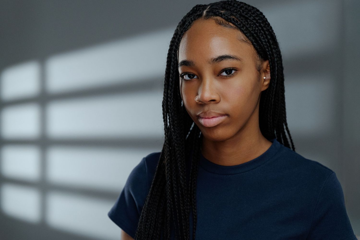 Studio portrait with natural lighting showcasing long braided hairstyle.