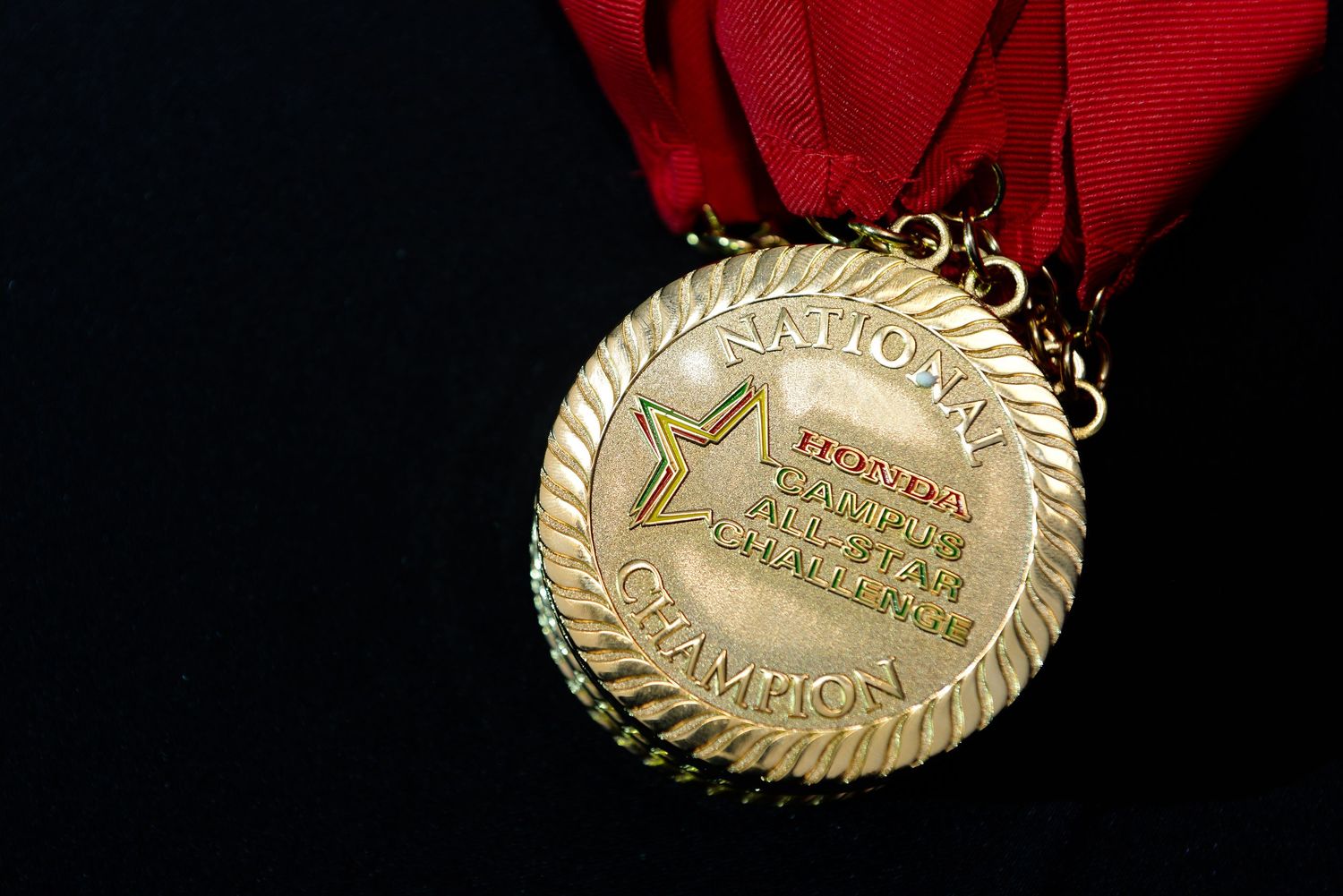 Close-up shots of gold medals with red ribbons against black background.