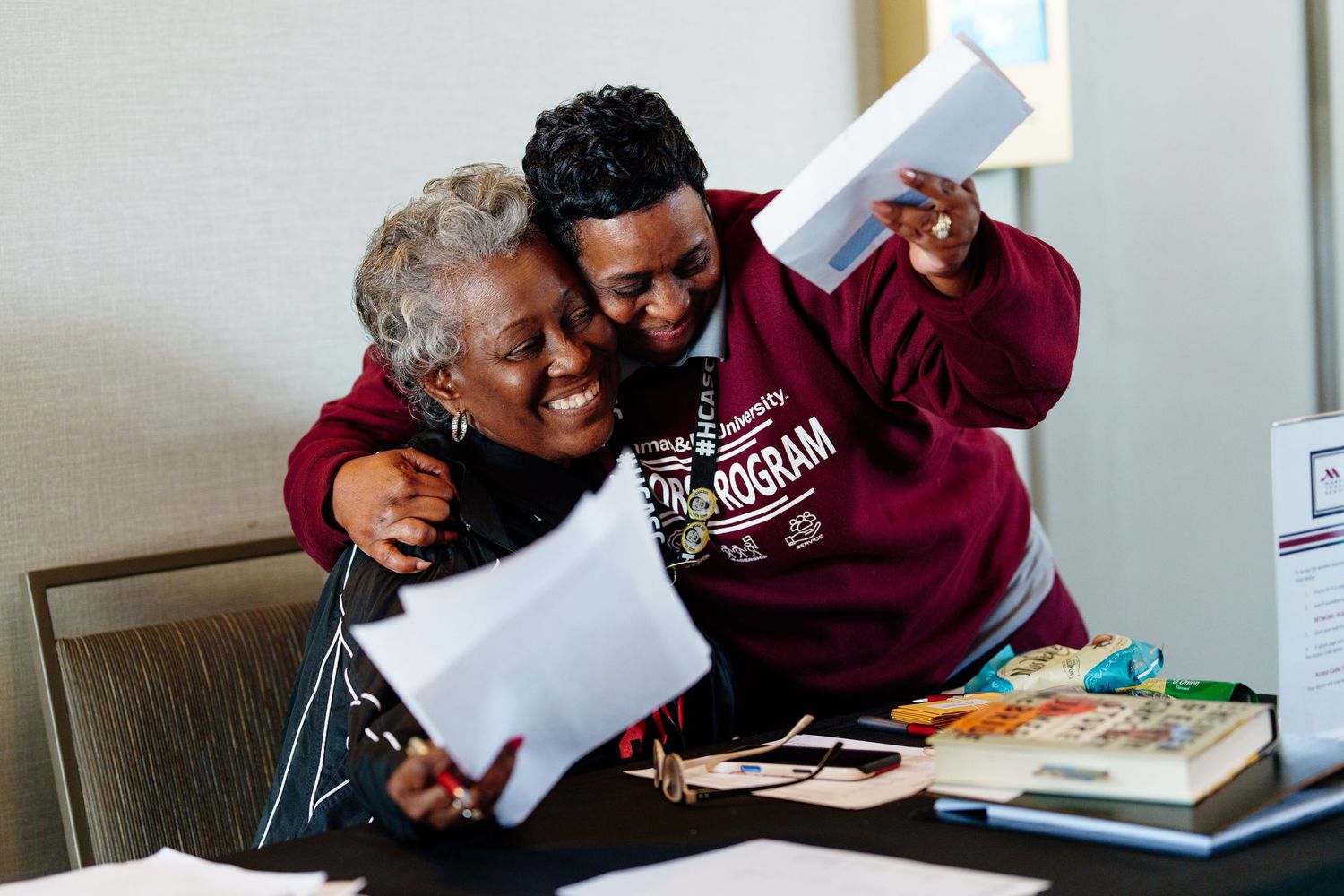 Two people sharing a joyful moment while looking at documents together.