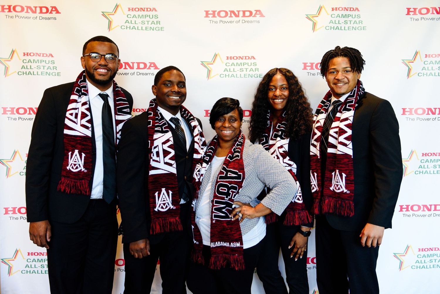 Group photo of participants wearing matching varsity-style jackets at a Honda sponsored event.