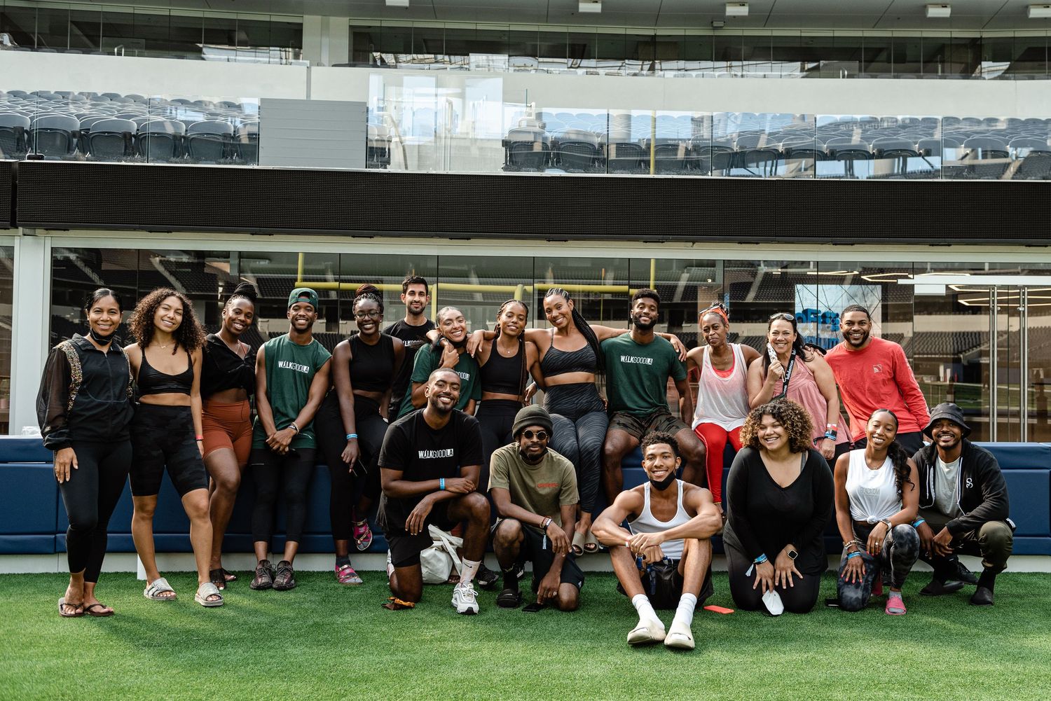 Group fitness enthusiasts gathered on an indoor sports field for a workout session.