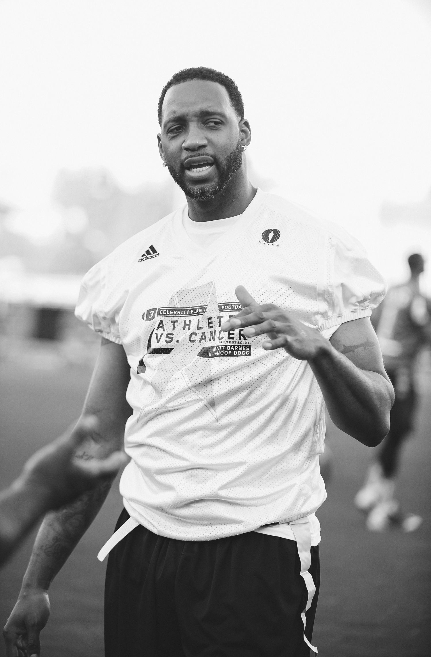 Black and white photo of someone in athletic wear smiling at a sports event.