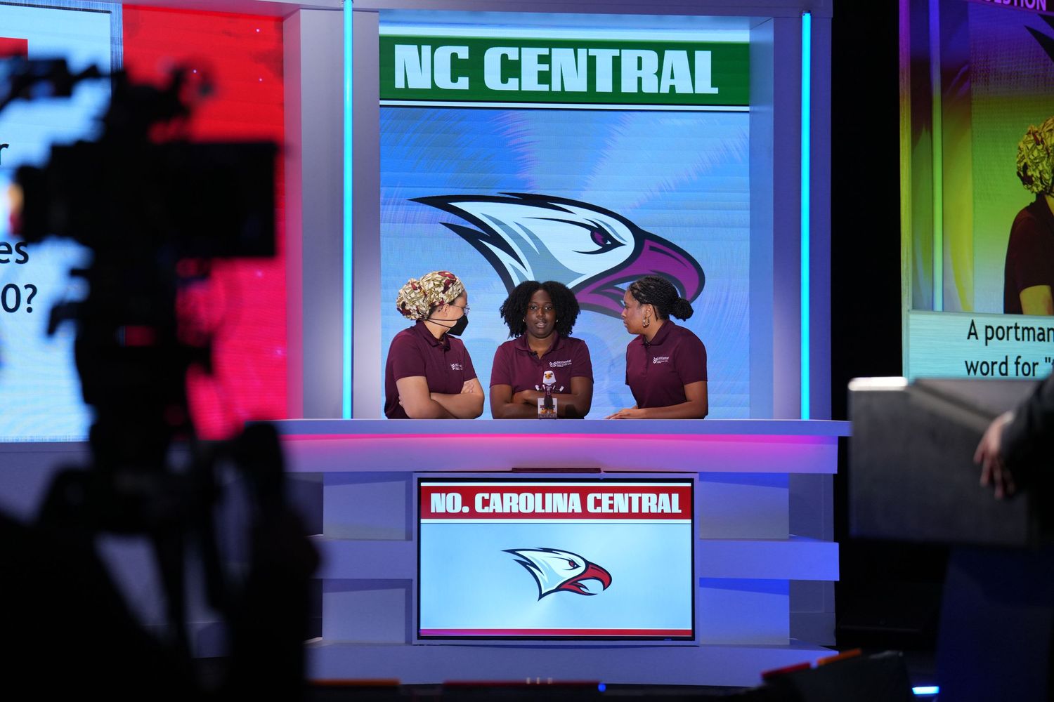 NC Central University students compete on a televised academic quiz show at a colorful studio set.