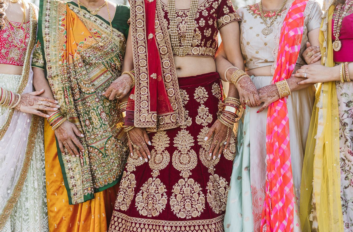 Close-up of colorful traditional Indian wedding saris with intricate embroidery and patterns.