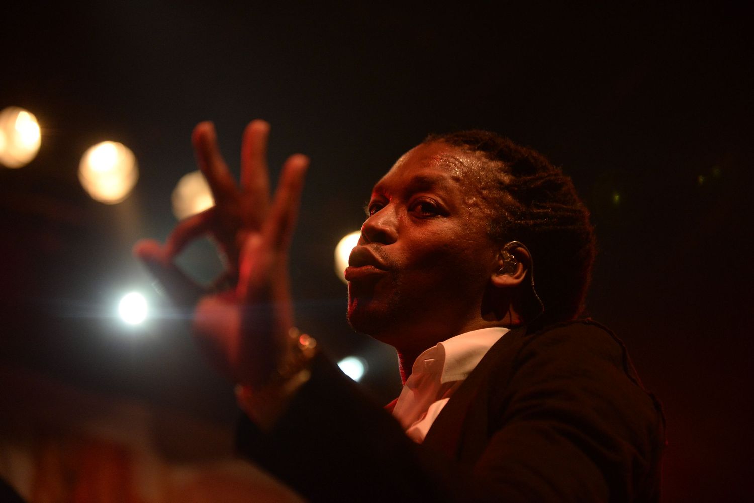 Dramatic concert performance with expressive gestures and stage lighting creating an emotional atmosphere.